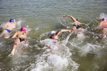 Visão aérea fêmea nadadores de águas abertas nadando no oceano ensolarado — Fotografia de Stock