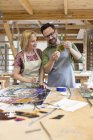 Stained glass artists examining glass pieces in studio — Stock Photo