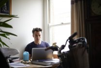 Мужчина работает на ноутбуке дома — стоковое фото