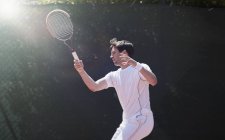 Jovem jogador de tênis masculino jogando tênis, balançando raquete de tênis — Fotografia de Stock