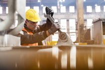 Stahlarbeiter benutzt großen Schraubenschlüssel in Fabrik — Stockfoto