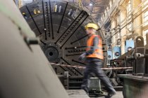 Movimento sfocatura vista laterale del lavoratore in acciaio a piedi in fabbrica — Foto stock