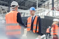 Male engineers handshaking at construction site — Stock Photo