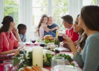 Granddaughter hugging grandfather at Christmas dinner table — Stock Photo