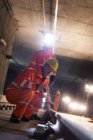 Bauarbeiter untersuchen U-Bahn-Gleise auf dunkler Baustelle — Stockfoto
