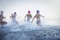 Nadadoras activas corriendo en el océano al aire libre - foto de stock