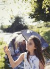 Любопытная девушка держит перо у палатки кемпинга — стоковое фото