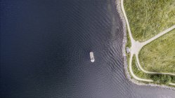 Vista aérea aérea del crucero en el océano ondulado a lo largo de la orilla, Frederikssund, Dinamarca - foto de stock