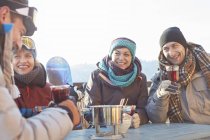 Snowboarder friends drinking cocktails on sunny patio apres-ski — Stock Photo