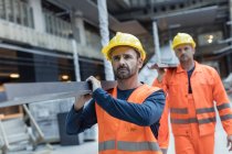 Construction workers carrying metal at construction site — Stock Photo
