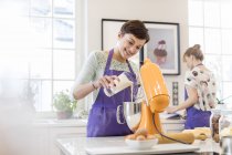 Fêmea cozimento caterer, usando misturador stand na cozinha — Fotografia de Stock