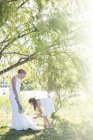 Подружка невесты и невесты, стоящие в саду во время свадебного приема — стоковое фото
