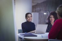 Smiling businesswomen working in conference room meeting — Stock Photo