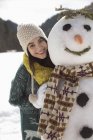 Портрет улыбающейся женщины со снеговиком — стоковое фото