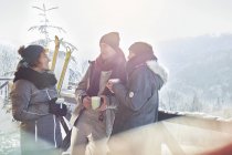 Skier friends talking, drinking coffee and hot cocoa apres-ski — Stock Photo