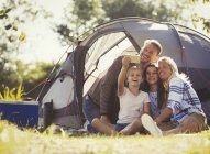 Famiglia scattare selfie con fotocamera telefono esterno tenda al campeggio soleggiato — Foto stock