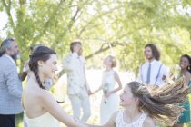 Dama de honra e menina dançando durante a recepção do casamento no jardim doméstico — Fotografia de Stock