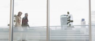 Бізнесмен і бізнес-леді, що йдуть на міському високогірному балконі — стокове фото