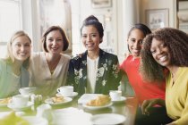 Retrato sorrindo mulheres amigos bebendo café na mesa do restaurante — Fotografia de Stock