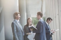 Geschäftsleute reden und lachen in sonniger Büro-Lobby — Stockfoto