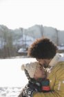 Homem beijando a testa da mulher na neve — Fotografia de Stock