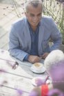 Seniorenpaar plaudert und trinkt Kaffee am sonnigen Terrassentisch — Stockfoto
