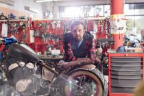 Портрет серйозного, впевненого механіка мотоциклів в майстерні — стокове фото