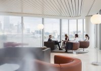 Reunión de empresarios en salón de oficinas urbano de gran altura - foto de stock