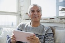 Портрет улыбающийся пожилой человек с помощью цифрового планшета — стоковое фото