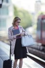 Бізнес-леді перевіряє свій годинник на вокзалі — стокове фото