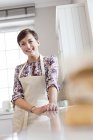 Porträt lächelnde brünette Frau in Schürze in der Küche — Stockfoto
