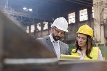 Manager and female steel worker meeting in factory — Stock Photo