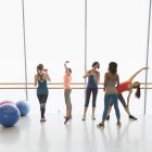 Women stretching and drinking water in exercise class gym studio — Stock Photo