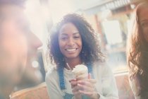 Ritratto sorridente giovane donna che beve milkshake con gli amici nel caffè — Foto stock