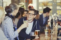 Amici che parlano e bevono birra al bar — Foto stock
