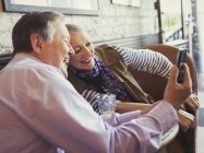 Lächelndes Senioren-Paar macht Selfie mit Kameratelefon am Cafétisch — Stockfoto