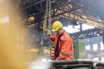Stahlarbeiter befestigt Kette in Fabrik — Stockfoto