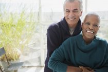 Retrato sonriente pareja mayor abrazándose en el porche del sol - foto de stock