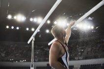 Мужской гимнаст наносит меловой порошок на параллельные брусья — стоковое фото