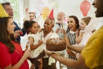 Multi-generation family celebrating birthday with chocolate cake — Stock Photo