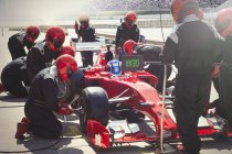 Equipaggio pozzo sostituzione gomme sulla Formula 1 auto da corsa in pit lane — Foto stock