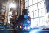 Welder welding with welding mask and torch in workshop — Stock Photo