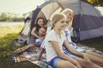 Smiling family relaxing outside campsite tent — Stock Photo