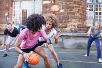 Amici che giocano a basket sul campo da basket urbano — Foto stock
