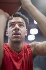 Primer plano enfocado joven jugador de baloncesto masculino tiro libre - foto de stock