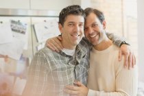 Портрет улыбающейся, ласковой гей-пары, обнимающейся на кухне — стоковое фото