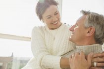 Affectionate mature couple hugging on sunny porch — Stock Photo