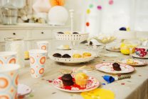 Pasteles y decoraciones en mesa de fiesta de cumpleaños - foto de stock