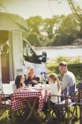 Famiglia godendo la prima colazione a tavola fuori solare camper — Foto stock