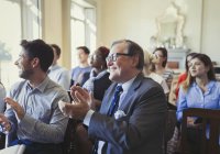 Gente de negocios sonriente aplaudiendo en audiencia de conferencia de negocios - foto de stock